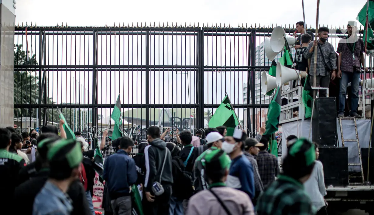 Sejumlah mahasiswa dari berbagai universitas melakukan orasi saat menggelar aksi di depan Gedung DPR, Jakarta, Selasa (6/9/2022). Dalam aksi tersebut mahasiswa menolak keputusan pemerintah menaikkan harga bahan bakar minyak (BBM) bersubsidi dan meminta pemerintah untuk meninjau ulang keputusan tersebut. (Liputan6.com/Faizal Fanani)