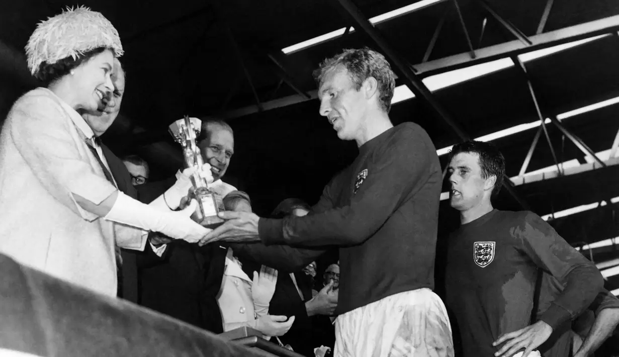 Kenangan Ratu Elizabeth II saat memberikan trofi Jules Rimet 1966 (saat ini Piala Dunia) ke kapten Inggris, Bobby Moore juga ditampilkan di 'big screen' stadion untuk mengenang kecintaan sang ratu kepada Timnas Inggris. (AFP)