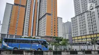 Bus yang mengangkut TKI dari luar negeri mengantre masuk untuk menjalani karantina di RSDC Wisma Atlet Kemayoran, Jakarta, Kamis (16/12/2021). Menkes Budi Gunadi Sadikin mengumumkan temuan kasus varian Omicron dari pekerja kebersihan di RSDC Wisma Atlet Kemayoran. (merdeka.com/Iqbal S. Nugroho)