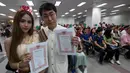 Sepasang suami istri memperlihatkan surat nikah mereka pada Hari Valentine di Bang Rak atau Distrik Cinta di Bangkok, Thailand, Jumat (14/2/2020). Banyak pasangan menikah di Distrik Cinta karena mereka percaya akan membawa keberuntungan dan cinta yang tahan lama. (AP Photo/Sakchai Lalit)