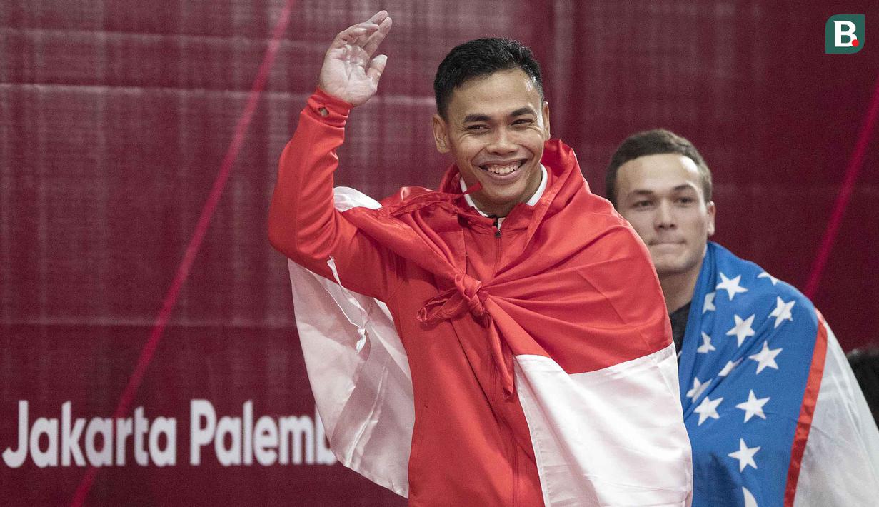 Lifter Indonesia, Eko Yuli Irawan, menyapa suporter usai berlaga pada Asian Games di JIExpo, Jakarta, Selasa, (21/8/2018). Eko Yuli berhasil menyumbang medali emas angkat besi putra kelas 62kg. (Bola.com/Peksi Cahyo)