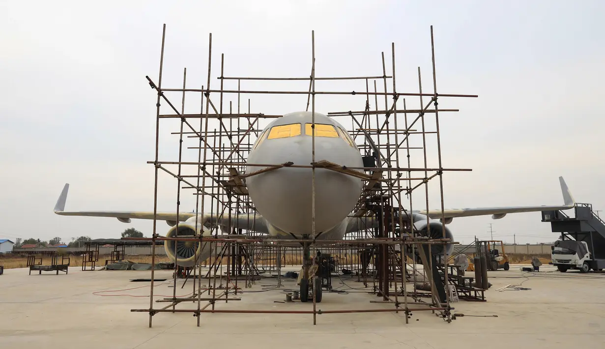 Orang-orang menyelesaikan pembuatan replika pesawat Airbus A320 skala penuh di Kaiyuan, timur laut China, 25 Oktober 2018. Secara keseluruhan, seorang petani bernama Zhu Yue telah menghabiskan 60 ton besi baja untuk membangun replika pesawat itu (STR/AFP)