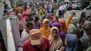 Orang-orang mengantre untuk menerima barang-barang gratis seperti pakaian, bahan makanan pokok, dan perlengkapan rumah tangga yang disediakan oleh Asosiasi Organisasi Wanita (GOW) dan pemerintah daerah selama acara aksi sosial tahunan di bulan Ramadan, Surabaya pada Senin 2 Maret 2026. (JUNI KRISWANTO/AFP)