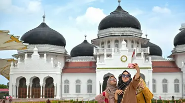 Sejumlah wisatawan memadati halaman Masjid Raya Baiturrahman saat libur lebaran Idulfitri 1444 H di Banda Aceh, Aceh, Selasa (25/4/2023). (AFP/CHAIDEER MAHYUDDIN)