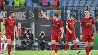 Gelandang AS Roma, Edoardo Bove (tengah), berpose merayakan golnya di depan pendukung Giallorossi yang memadati Stadion Olimpico Roma dalam laga kontra Bayer Leverkusen di leg pertama semifinal Liga Europa, Jumat (12/5/2023) dini hari WIB. AS Roma menang 1-0 atas wakil Jerman itu dalam pertandingan ini. (Alberto PIZZOLI / AFP)