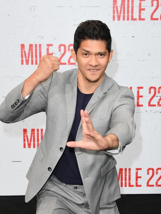 Bintang laga, Iko Uwais memamerkan gerakan pencak silat ketika menghadiri acara gala premier film Mile 22 di Los Angeles, Kamis (9/8). Iko Uwais tampil dalam balutan setelan jas abu-abu yang dipadukan dengan kaus warna gelap. (AFP PHOTO / Mark RALSTON)