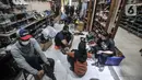 Calon pembeli saat menjajal seatu impor bekas di toko Second BJR, Kali Baru Timur, Cilincing, Jakarta Utara, Rabu (1/6/2022). Harga sepatu impor bekas mulai dijual oleh Bajuri kisaran Rp250 ribu hingga Rp7 juta per pasang. (merdeka.com/Iqbal S. Nugroho)