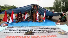 Petani Kendeng yang tergabung dalam Jaringan Masyarakat Peduli Pegunungan Kendeng (JM-PPK) mendirikan tenda di depan Istana Merdeka, Jakarta, Senin (4/9). Mereka kembali melakukan unjuk rasa dan menggelar aksi teatrikal. (Liputan6.com/Johan Tallo)