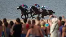  Para joki memacu kudanya dalam pacuan kuda pantai di Sanlucar de Barrameda, Spanyol, (27/8/2016). (AFP/Jorge Guerrero)