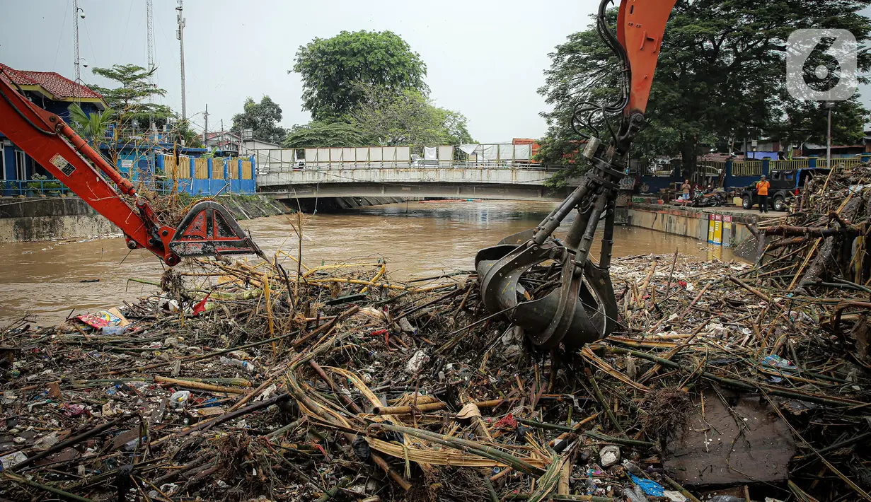 Petugas Dinas Kebersihan DKI Jakarta menggunakan alat berat untuk membersihkan sampah di Pintu Air Manggarai, Jakarta, Senin (10/10/2022). Hujan lebat yang mengguyur wilayah Bogor dan sekitarnya menyebabkan debit air Sungai Ciliwung meningkat dan menghanyutkan sampah ke Pintu Air Manggarai. (Liputan6.com/Faizal Fanani)