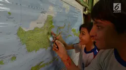 Sejumlah siswa mencari lokasi calon ibu kota baru pada peta saat kegiatan belajar bertema wawasan Nusantara di SDN Menteng 02, Jakarta, Selasa (27/8/2019). Kegiatan belajar wawasan Nusantara itu memberitahukan lokasi pemindahan ibu kota RI dari Jakarta ke Kalimantan Timur.(merdeka.com/Imam Buhori)