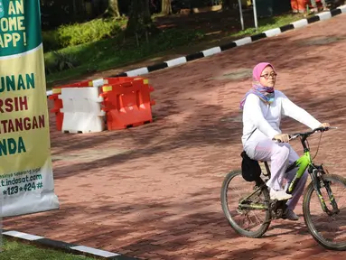 Warga bersepeda melintas di salah satu bundaran di kawasan Kebun Binatang Ragunan, Jakarta, Minggu (9/10). Kawasan KBR menjadi salah satu lokasi alternatif warga Jakarta untuk berolahraga pada Minggu pagi. (Liputan6.com/Helmi Fithriansyah)
