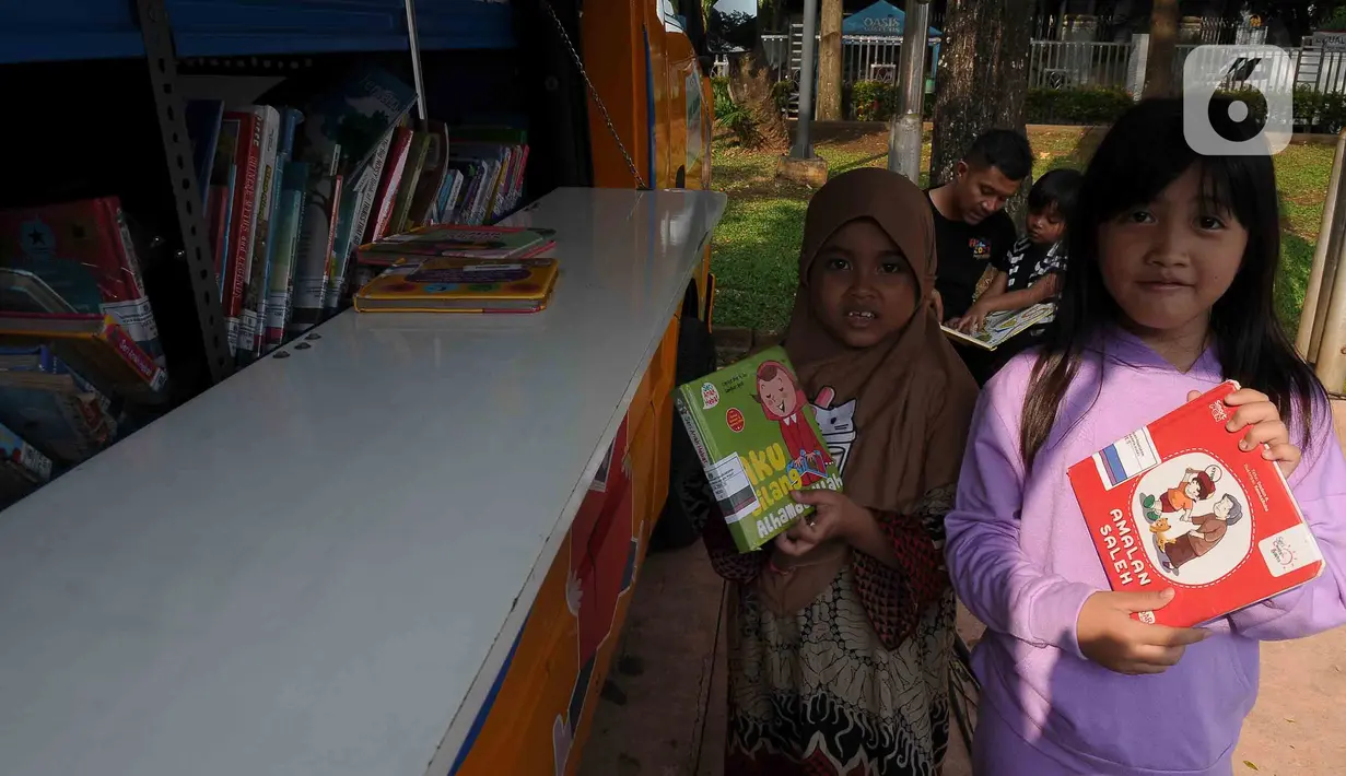 Anak-anak menunjukkan buku untuk di baca di Taman Menteng, Jakarta Senin (14/8/2023). (merdeka.com/imam buhori)