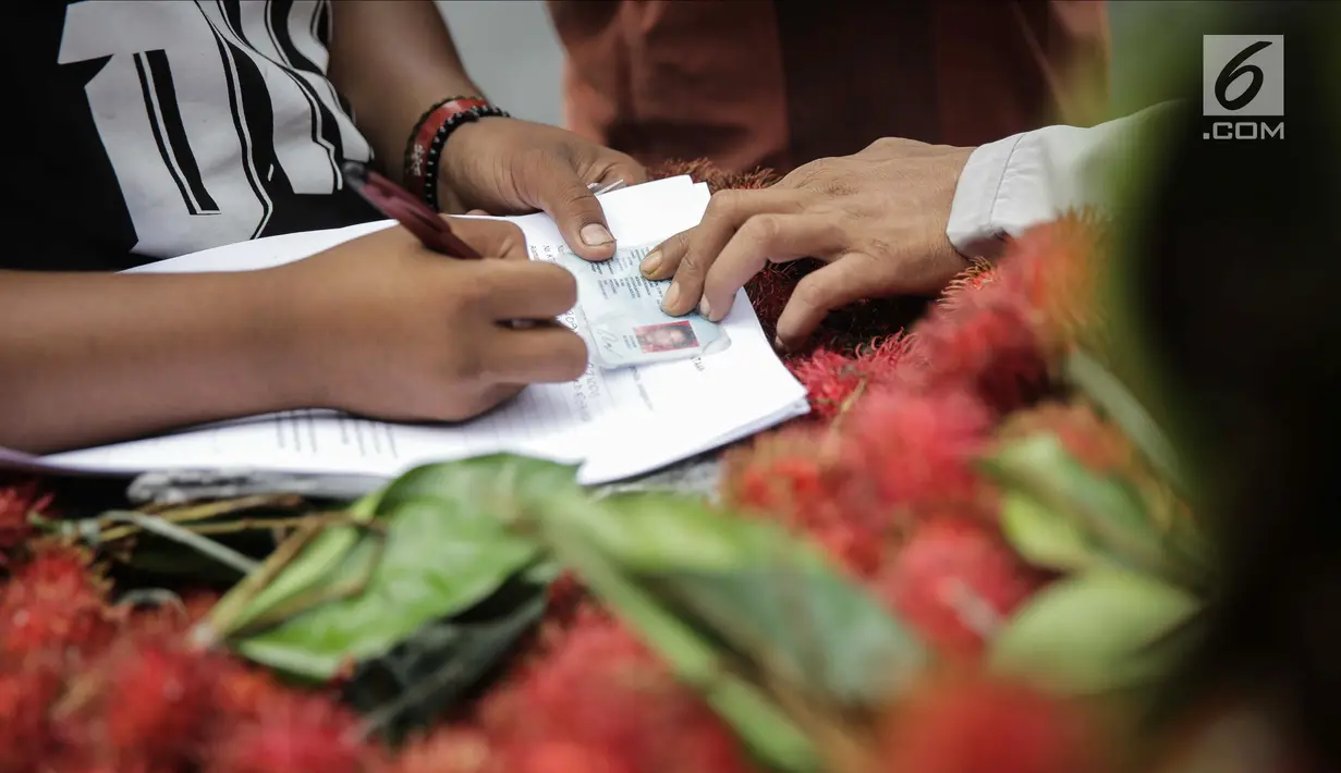 Pedagang buah rambutan mengisi surat pernyataan saat ditindak oleh Petugas Dinas Perhubungan di CFD di kawasan Bunderan HI, Jakarta, Minggu (4/2). (Liputan6.com/Faizal Fanani)