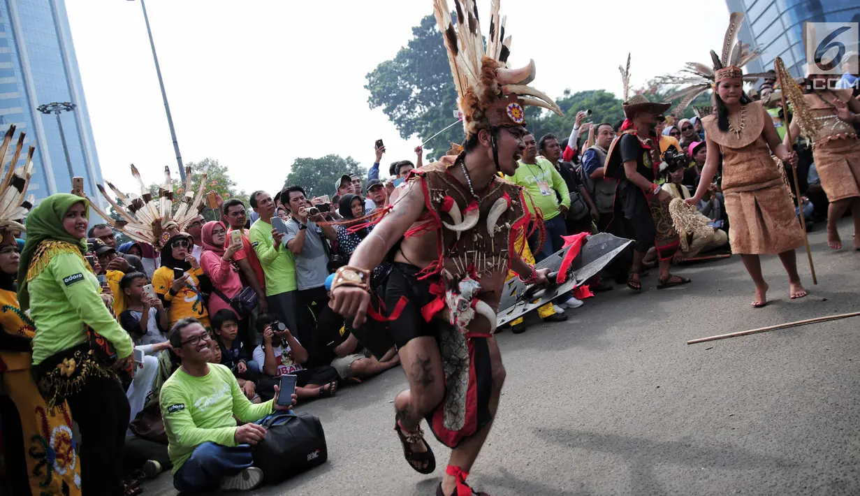 Atraksi budaya dayak meramaikan Car Free Day (CFD) di kawasan Sudirman, Jakarta, Minggu (29/10). Kegiatan dengan nama Gelar Pesona Budaya Tabalong itu digelar untuk menunjukkan karya seni tradisional Tabalong. (Liputan6.com/Faizal Fanani)