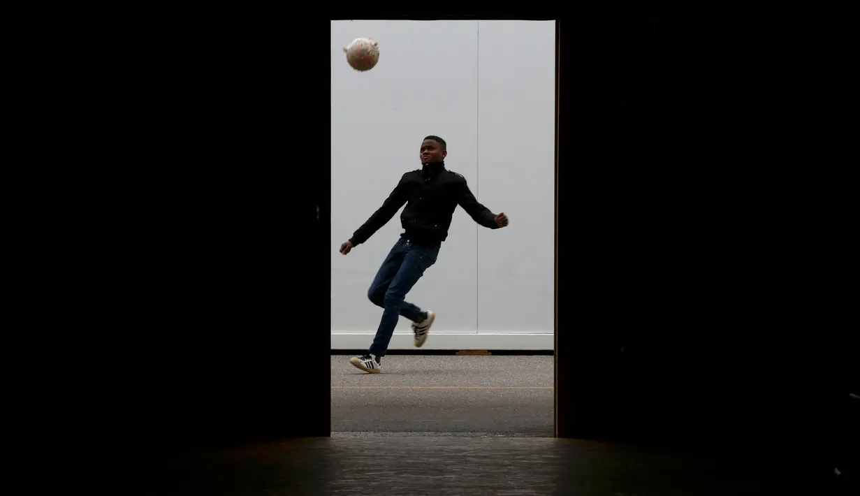 Seorang anak laki-laki migran bermain bola di luar Pusat Pengungsi Federal Swiss Federal di Thun, Swiss, (22/3/2016). (Reuters/Ruben Sprich