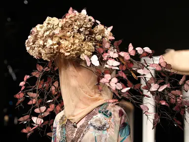 Model mengenakan topi dan hiasan kepala unik saat memeragakan koleksi Musim Semi-Musim Panas 2019 di Milan Fashion Week, Milan, Italia, Jumat (21/9). Hiasan kepala mulai dari tumbuhan hingga kupu-kupu. (AP Photo/Antonio Calanni)