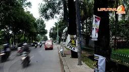 Bendera Parpol masih terpasang di jalan depan Universitas Pancasila Jakarta pada Sabtu (05/04/14) (Liputan6.com/Helmi Fithriansyah).  