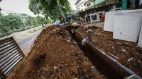 Pekerja menyelesaikan proyek perbaikan saluran air di Jalan Latuharhari, Jakarta, Jumat (14/11/2014). (Liputan6.com/Faizal Fanani)