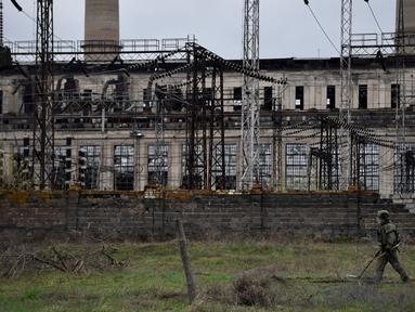 Seorang tentara Rusia menjinakkan pembangkit listrik Luhansk di kota Shchastya (13/4/2022). Pembangkit listrik Luhansk adalah pembangkit listrik termal di utara Shchastia, dekat Luhansk, Ukraina. (AFP/ Alexander Nemenov)