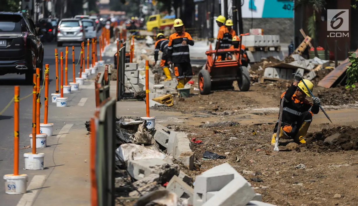 Pekerja menyelesaikan proyek revitaslisasi trotoar di kawasan Cikini, Jakarta, Senin (1/7/2019). Revitalisasi trotoar di kawasan Cikini hingga Kramat ditargetkan rampung pada Desember 2019. (Liputan6.com/Faizal Fanani)