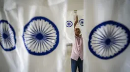 Seorang pegawai pemerintah memasang bendera nasional India di bawah produksi untuk dikeringkan di kantor menjelang Hari Kemerdekaan di Gauhati, di negara bagian Assam, Selasa, 2 Agustus 2022. Perdana Menteri India Narendra Modi telah mengimbau warga untuk mengibarkan atau memajang bendera nasional di Hari Kemerdekaan pada 15 Agustus. (AP Photo/Anupam Nath)