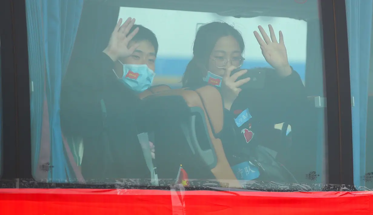 Petugas medis yang diperbantukan ke Provinsi Hubei melambaikan tangan dari dalam bus saat tiba di Bandara Internasional Taoxian Shenyang, Shenyang, Provinsi Liaoning, China, Jumat (20/3/2020). Mereka dipulangkan seiring meredanya wabah virus corona COVID-19 di Hubei. (Xinhua/Long Lei)