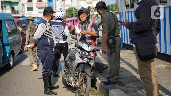 Petugas Dinas Perhubungan melakukan sosialisasi penggunaan masker kepada pengendara sepeda motor di kawasan Depok, Jawa Barat, Senin (20/7/2020). Setelah sosialisasi, Pemkot Depok akan menerapkan sanksi denda kepada warga yang melanggar. (Liputan6.com/Immanuel Antonius)