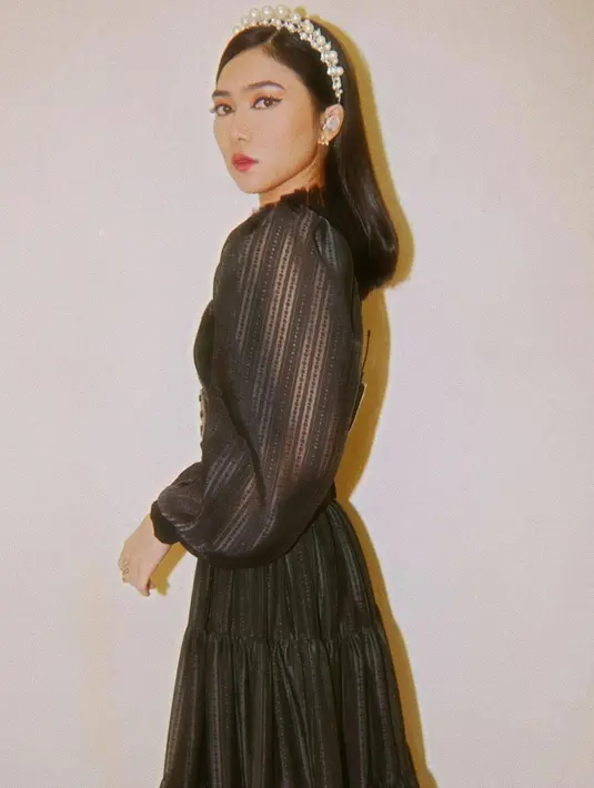 Simple dress hitam yang digunakan oleh Isyana satu ini pun terlihat sederhana namun memiliki detail yang cantik. Bahkan, ia terlihat begitu memesona dengan hiasan kepala mutiara. (Liputan6.com/IG/@isyanasarasvati)
