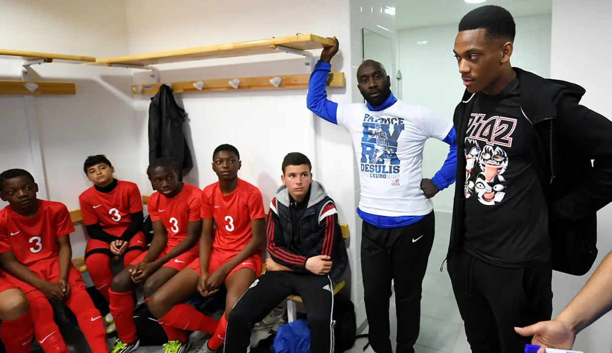 Pemain Timnas Prancis, Anthony Martial, memberi wejangan kepada para pemain muda Les Ulis di ruang ganti sebelum bertanding, (23/5/2016). (AFP/Franck Fife) 