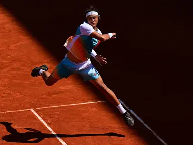 Petenis China, Zhang Zhizhen berusaha mengembalikan bola ke arah petenis Norwegia, Casper Ruud pada laga hari ketujuh Prancis Terbuka 2023 di Roland Garros, Paris, 3 Juni 2023. (AFP/Emmanuel Dunand)