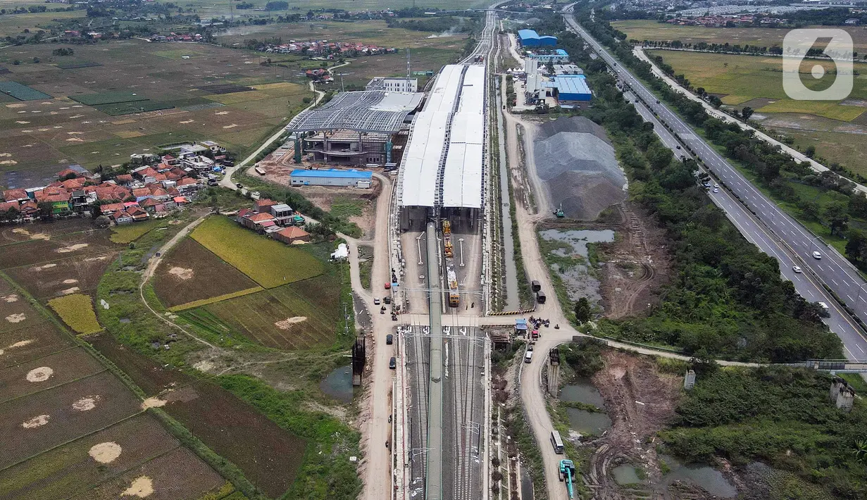 Foto udara suasana pembangunan Stasiun Tegalluar di Kabupaten Bandung, Jawa Barat, Kamis (13/10/2022). Progres pembangunan proyek Kereta Cepat Jakarta-Bandung telah mencapai 88,8 persen dan direncanakan beroperasi pada Juli 2023. (Liputan6.com/Herman Zakharia)