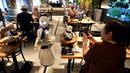 Robot humanoid mengantarkan minuman kepada pelanggan di Dawn Cafe, Tokyo, Jepang, 17 Agustus 2021. Peluncuran kafe ini bersamaan dengan Paralimpiade yang akan dibuka pada 24 Agustus. (Behrouz MEHRI/AFP)