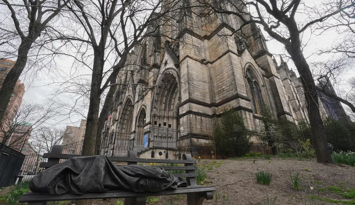Patung orang yang tidur terlihat di bangku halaman Katedral St. John the Divine yang akan menjadi rumah sakit lapangan untuk menangani pasien virus corona (Covid-19) di New York, 7 April 2020.  Saat ini New York menjadi negara bagian yang memiliki kasus corona tertinggi di AS. (Bryan R. Smith/AFP)