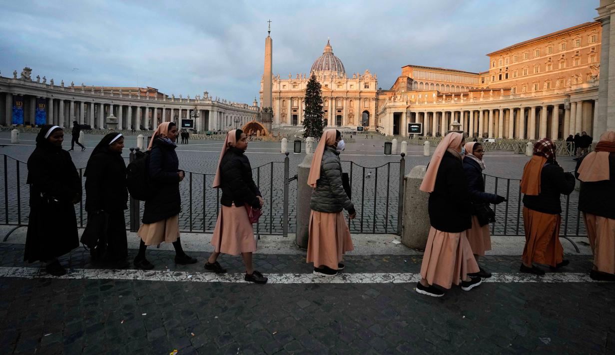 Para biarawati mengantre untuk memasuki Basilika Santo Petrus tempat mendiang Paus Emeritus Benediktus XVI disemayamkan di Vatikan, Senin (2/1/2023). Benediktus XVI, teolog Jerman yang akan dikenang sebagai paus pertama dalam 600 tahun yang mengundurkan diri, telah meninggal pada 31 Desember 2022 di usia 95 tahun. (AP Photo/Alessandra Tarantino)