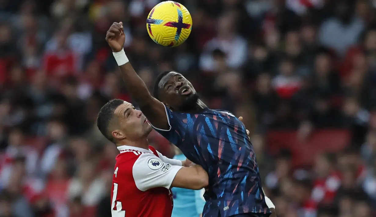 Bek Nottingham Forest, Serge Aurier (kanan) berebut bola dengan gelandang Arsenal, Granit Xhaka pada laga Liga Inggris 2022/2023 di Emirates Stadium, London (30/10/2022). Pemain asal Pantai Gading ini didatangkan Nottingham Forest pada awal musim 2022/2023 saat berstatus tanpa klub setelah sebelumnya membela Villarreal. Ia dikontrak hanya setahun hingga Juni 2023. Di Liga Inggris 2022/2023 ia telah bermain 15 kali dengan torehan 1 gol. (AFP/Ian Kington)