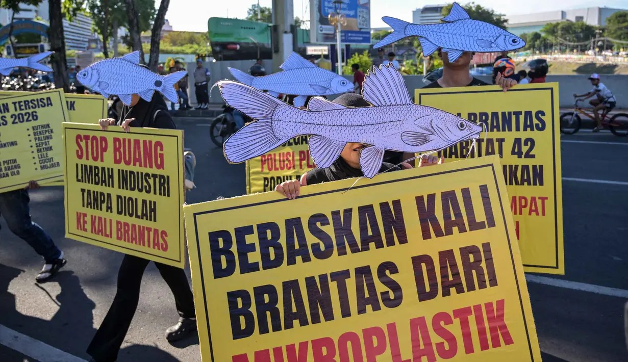 Aktivis dari Ecoton (Pengamatan Ekologi dan Konservasi Lahan Basah) yang mengenakan topeng ikan ikut serta dalam unjuk rasa menyerukan sungai bersih bebas sampah dan limbah industri, serta perlindungan ikan sungai, sebagai bagian dari perayaan Hari Lingkungan Hidup Sedunia di Surabaya, Jawa Timur, Jumat 5 Juni 2026. (JUNI KRISWANTO/AFP)