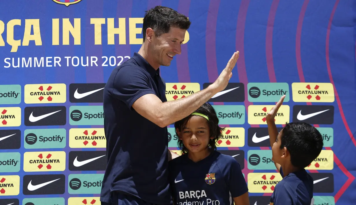 Pemain sepak bola Polandia Robert Lewandowski menyapa para pemain dari Barca Academy saat diperkenalkan sebagai pemain baru Barcelona di Fort Lauderdale, Florida, Rabu (20/7/2022). Pada kesempatan itu Lewandowski juga melakukan ramah tamah dengan sejumlah pemain Barca Academy. (Marco BELLO / AFP)