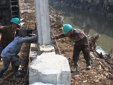 Sejumlah pekerja memasang tiang pancang untuk turap bantaran Kali Ciliwung, Kampung Pulo, Jakarta (26/8/2015). Pemprov DKI Jakarta menargetkan pemasangan turap selesai dalam waktu tiga bulan. (Liputan6.com/Gempur M Surya)