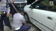 Petugas Dishub Jakarta Pusat menderek mobil yang parkir di trotoar jalan di kawasan jalan Gajah Mada