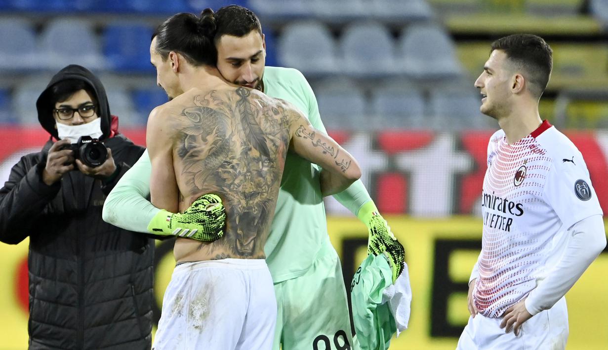 Kiper AC Milan, Gianluigi Donnarumma, memeluk Zlatan Ibrahimovic, usai laga melawan Cagliari pada laga Liga Italia di Sardegna Arena, Senin (19/1/2021). AC Milan menang dengan skor 2-0. (AFP/Alberto Pizzoli)