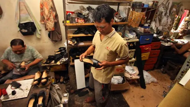 Joko Semedi, pengrajin selop manten mengamati proses pengerjaan produknya.