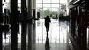 Seorang perempuan berjalan di terminal kedatangan Bandara Internasional Noi Bai yang nyaris kosong di Hanoi, Vietnam, Kamis (27/2/2020). Jumlah penumpang pesawat menurun di tengah ancaman infeksi virus corona yang bernama resmi  COVID-19. (Mladen ANTONOV/AFP)