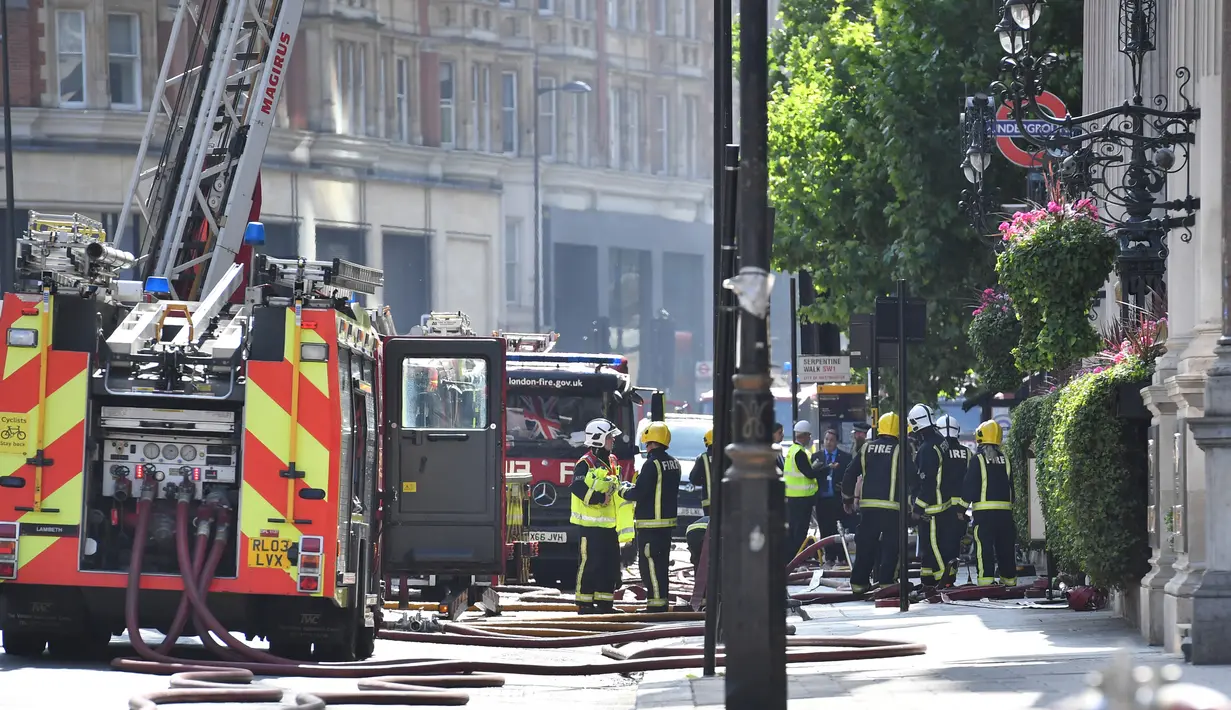 Petugas pemadam kebakaran berusaha menjinakkan kobaran api di hotel Mandarin Oriental, London, Rabu (6/6). Hotel ini menjadi tempat pertama kali Yang Mulia Ratu Elizabeth II dan adiknya, mendiang Putri Margaret belajar berdansa. (AFP / Ben STANSALL)