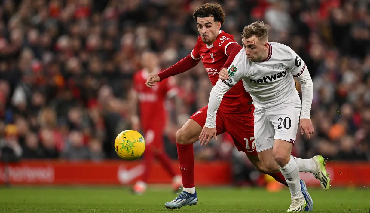 Pemain Liverpool, Curtis Jones (kiri) berebut bola dengan pemain West Ham United,Jarrod Bowen pada laga perempat final Carabao Cup 2023/2024 di Anfield, Liverpool, Inggris, Kamis (21/12/2023) dini hari WIB. (AFP/Oli Scarff)