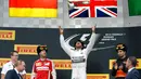 Pembalap Formula Satu (F1) tim Mercedes, Lewis Hamilton melempar trofi miliknya ke udara saat merayakan kemenangan usai ajang balap GP F1 Rusia di Sochi, Minggu (11/10). Lewis Hamilton berhasil memenangkan lomba Formula GP Rusia. (REUTERS/Grigory Dukor)