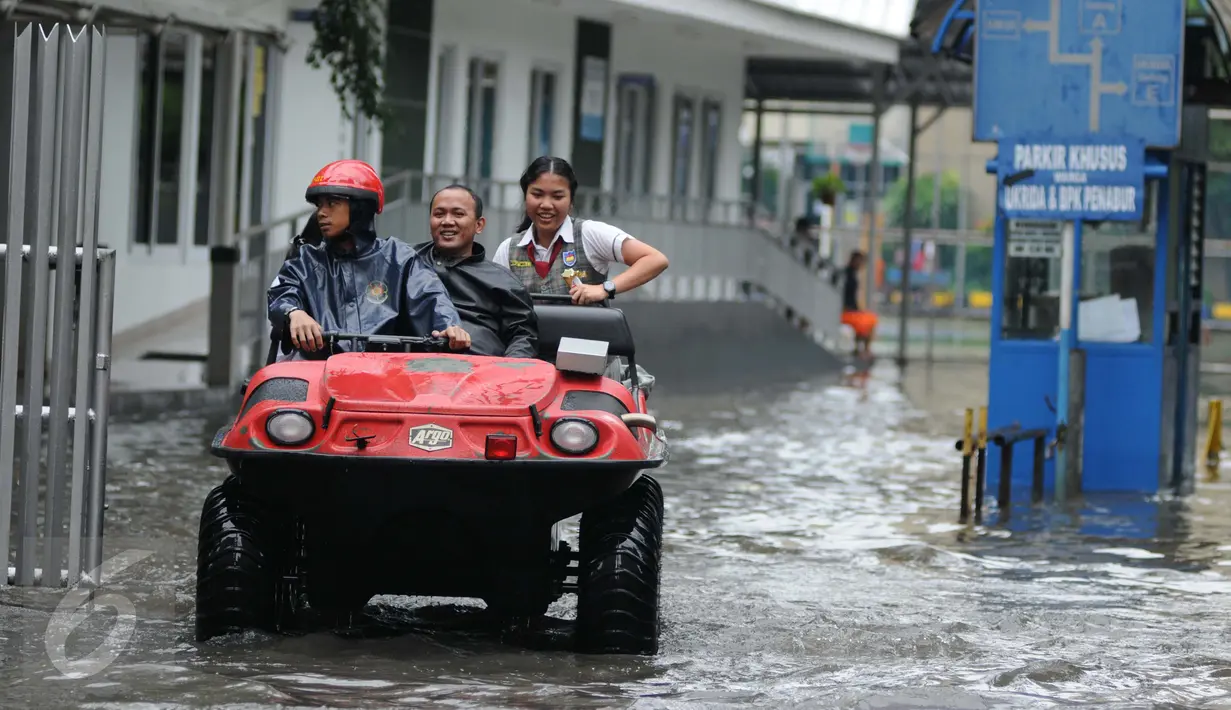 Pelajar dibantu mobil amfibi melewati genangan air di depan kampus UKRIDA, Jakarta, Selasa (21/1). Hujan deras sejak malam tadi, membuat sejumlah wilayah Jakarta tergenang air banjir. (Liputan6.com/Gempur M Surya)