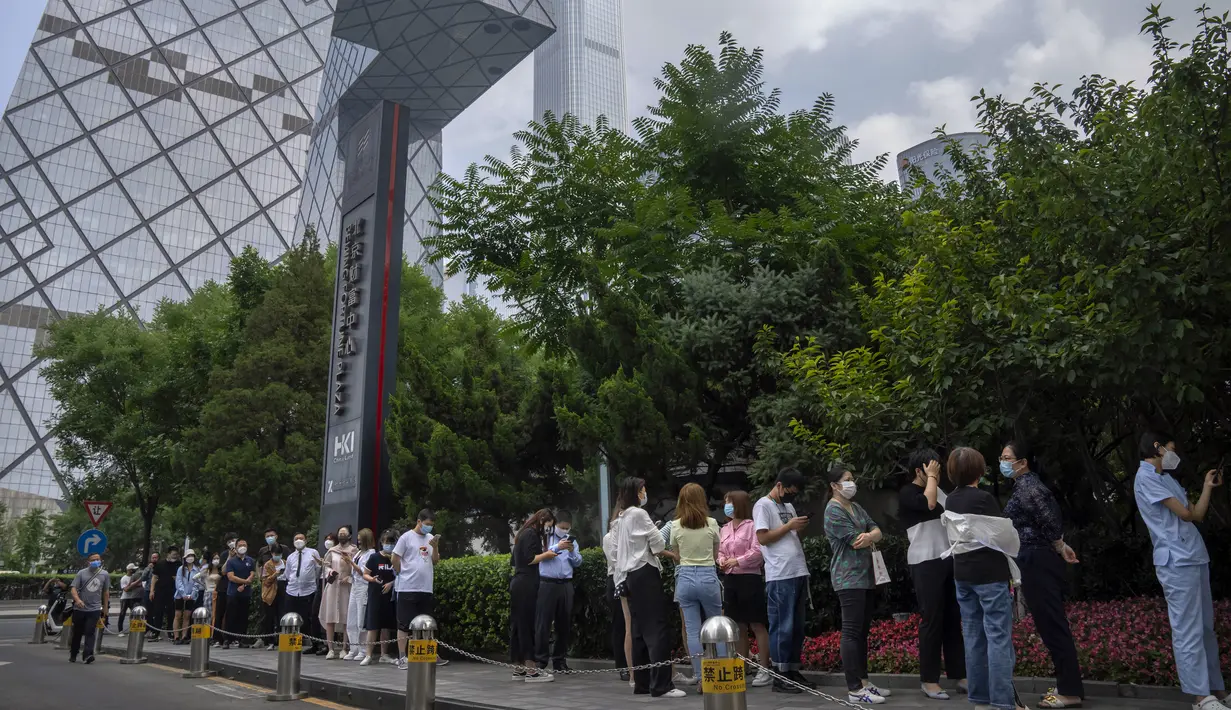 Orang-orang yang mengenakan masker mengantre di tempat pengujian virus corona COVID-19 pada hari ketiga tes massal untuk jutaan penduduk di Distrik Chaoyang, Beijing, China, 15 Juni 2022. (AP Photo/Mark Schiefelbein)