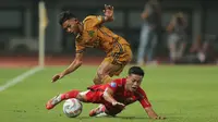 Pemain Persija Jakarta, Rio Fahmi (bawah) terjatuh saat berebut bola dengan pemain Bhayangkara FC, Sani Rizki pada laga pekan ke-20 BRI Liga 1 2023/2024 di Stadion Patriot Candrabhaga, Bekasi, Senin (27/11/2023). (Bola.com/M Iqbal Ichsan)