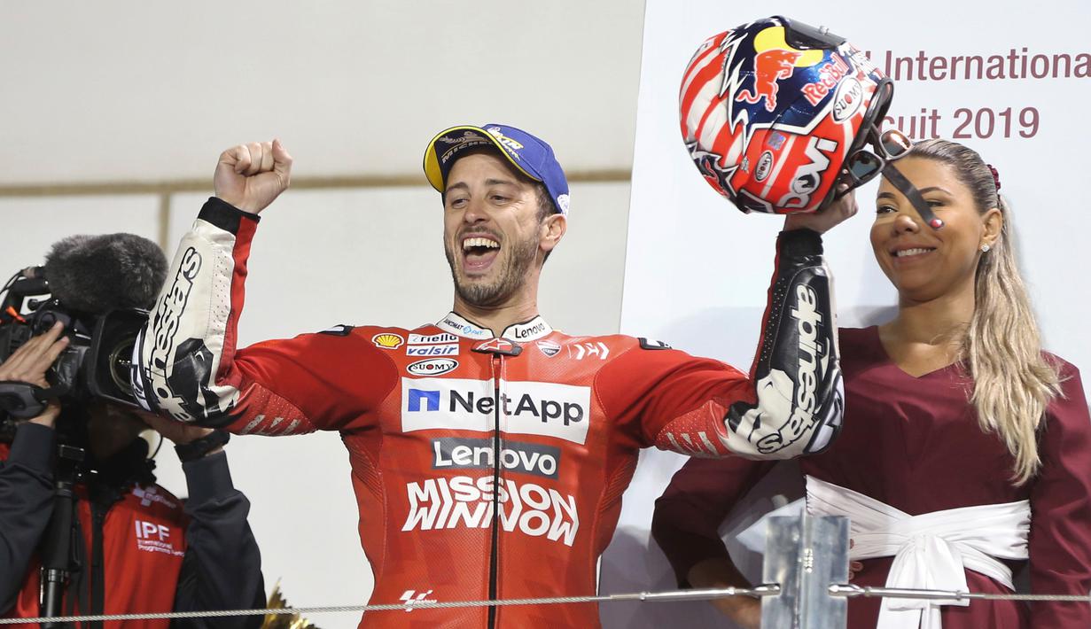 Pembalap Ducati, Andrea Dovizioso berselebrasi usai berhasil memenangkan seri pembuka MotoGP di Sirkuit Internasional Losail di Doha, Qatar (10/3). Dovizioso berhasil mengalahkan Marc Marquez dengan selisih waktu 0,023 detik. (AP Photo/Hanson Joseph)